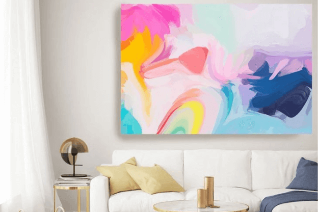 Photo of living room with oversized abstract art hanging over a white sofa to illustrate the large-scale art trend