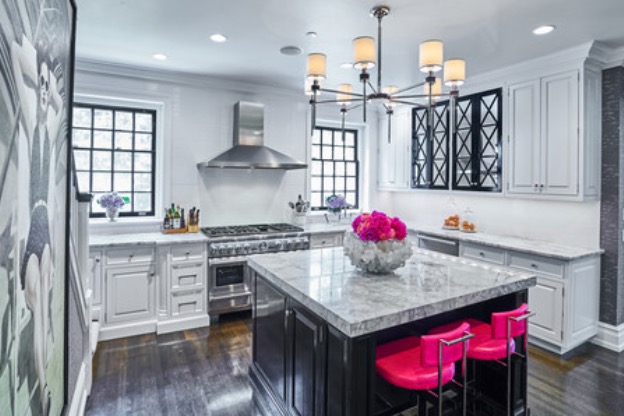 Photo of black and white kitchen with hot pink bar chairs and floral accents to illustrate how to add a pop of pink to your home.