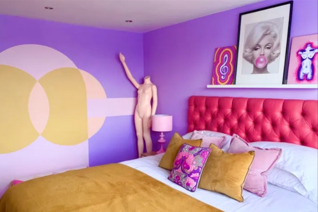 Photo of a bedroom containing DIY wall art, mixed art prints, and a nude mannequin to illustrate using unique objects to decorate your home like Weird Barbie.