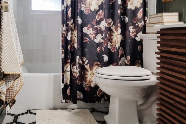 Eclectic bathroom with wood detailing, dark floral shower curtain, and plush linens