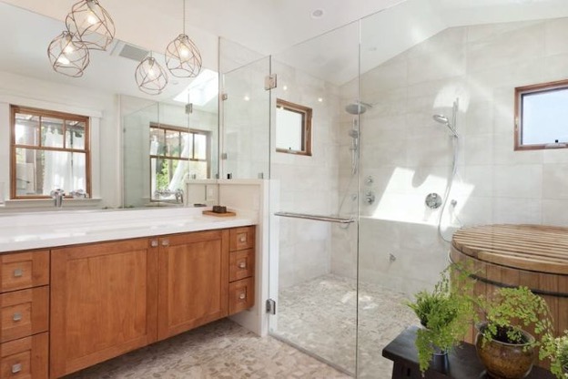 Brightly-lit wood grain and white marble bathroom with zero-entry luxury shower
