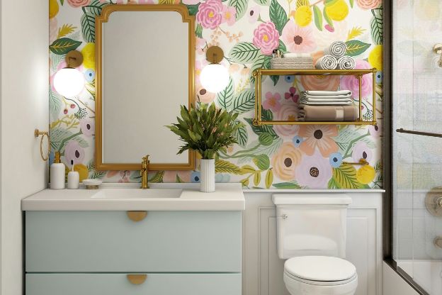 Bathroom with floral wall paper and light blue vanity.